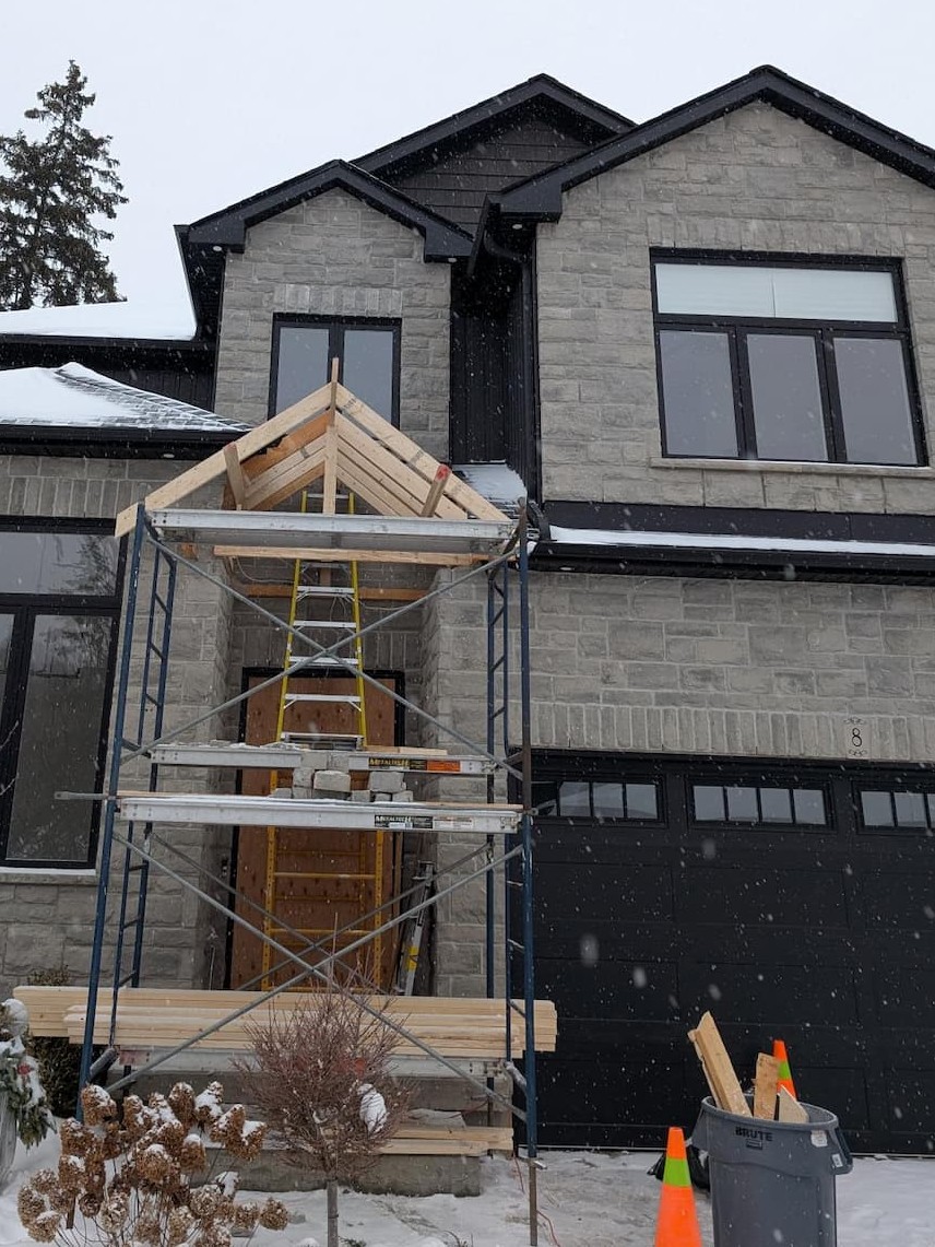 Timber-frame entry gable under construction with scaffolding during a Kitchener front facade renovation
