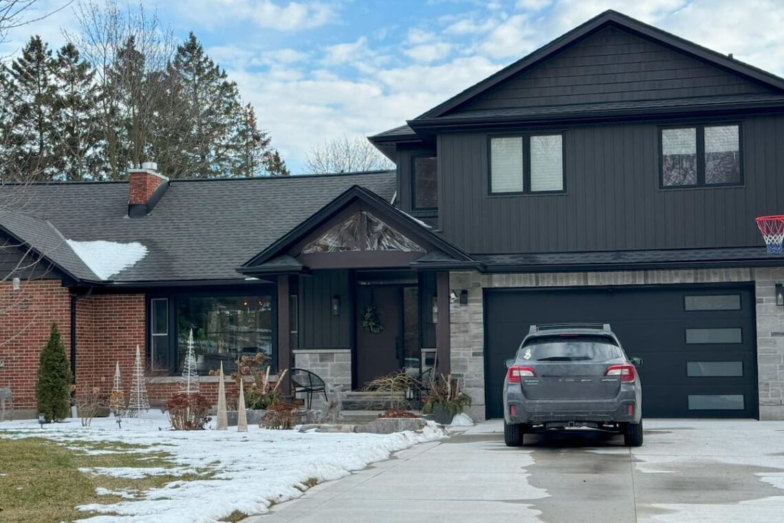 Kitchener home after external renovation. Grey brick with black siding and accents.