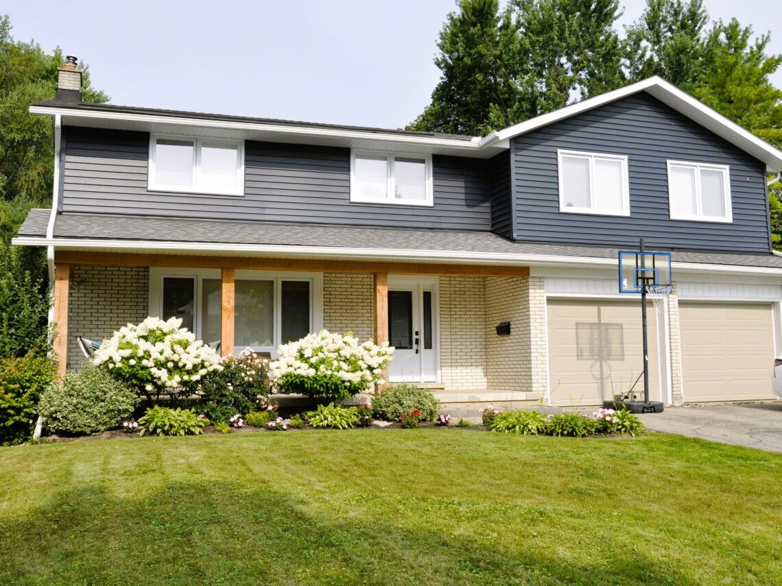 Second-storey addition on a Kitchener home with dark siding and a new covered front porch.