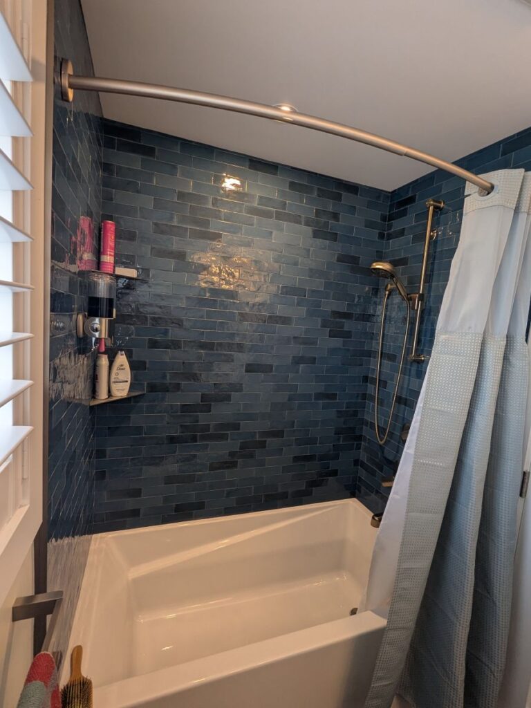 Waterloo bathroom tub after renovation. Sleek blue and black tile.